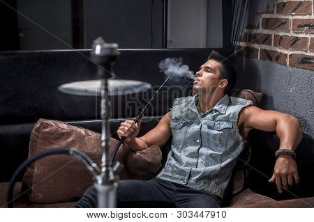 Young Fellow In The Hookah Room In Hookah Cafe.