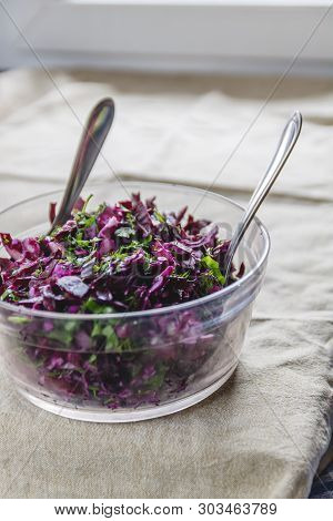 Fresh Blue Cabbage Salad With Herbs And Nuts In A Glass Bowl On A Rustic Tablecloth. Pour Over The S