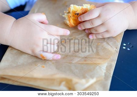 Close Up Hand Little Cild Having Breakfast In The Cafe On The City Street. The Child Is Eating A Cro