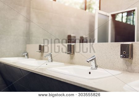 Modern Interior Design In Public Toilet. New Sinks, Taps With Mirror And Window Above