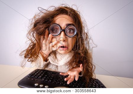 Funny nerd girl working on computer