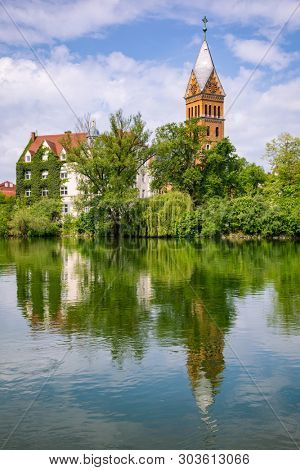 Landshut townscape with Christ Church (Christuskirche) reflecting in Isar river on a bright spring day, Bavaria, Germany, Europe