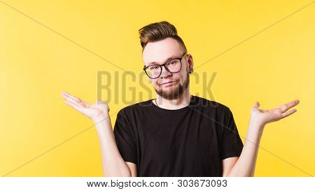 Life Happens. Portrait Of Confused Millennial Guy Shrugging Shoulders Helplessly. Indifferent Facial