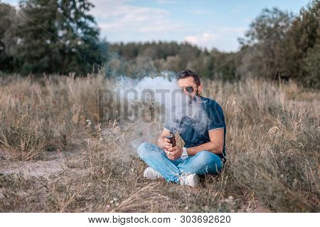 Stylish Vaper Exhales Cloud Of Smoke. Smoking Cessation Tobacco.