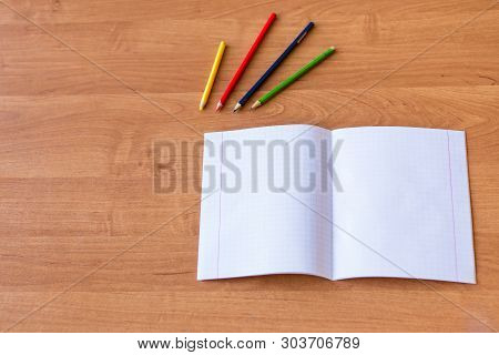 Pure Noteboks And Colorful Pencils On The Wooden Desk. Concept Of School Education