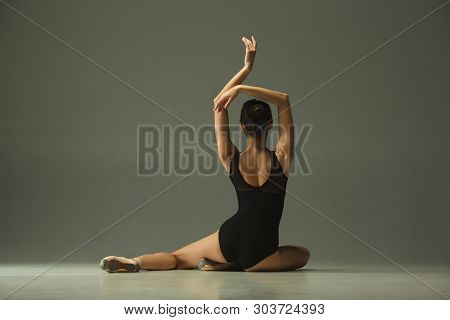 Graceful Ballet Dancer Or Classic Ballerina Dancing Isolated On Grey Studio Background. Showing Flex