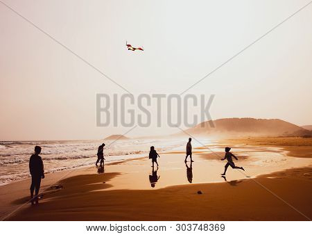 Karpasia, Cyprus - 14 April, 2019: Atmospheric Capture Of Silhouettes Of People Playing And Flying A