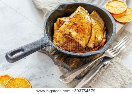 Traditional French Crepe Suzette With Orange Sauce In A Cast Iron Pan, Selective Focus.