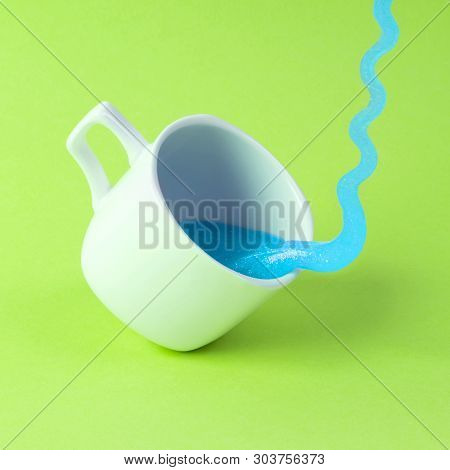 Bright Blue Glitter Slime Comes In Mug. White Cup On Green Background. Art Neon Surrealism And Minim