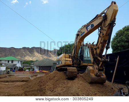 Honolulu - Construction Cat Bulldozer Sits In Empty Dirt Lot In Kapahulu With Diamond Head In The Di