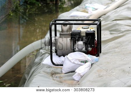 New Petrol Water Pump With Strong Metal Frame Left On Side Of Improvised Sandbags Flood Protection W