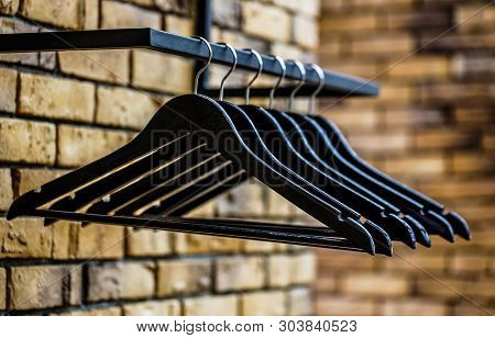 Many Wooden Black Hangers On A Rod. Store Concept, Sale, Design, Empty Hangers. Black Friday. Wooden