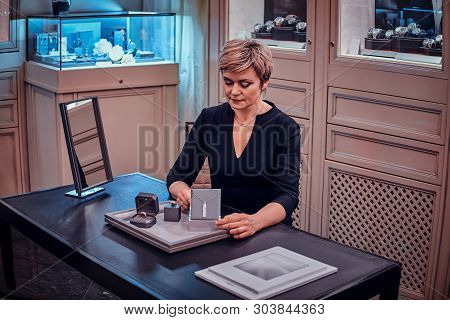 Elegant Jewellery Store Assistant Is Showing Beatiful Jewel Necklace For Customer.