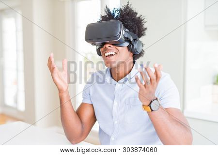 African amaerican man having fun playing with virtual reality glasses