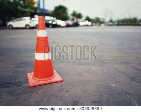 Red Rubber Cone On Concrete Floor In Gas Station, Blurred Background Image