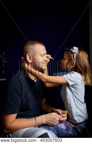 Daughter And Father Paint A Face, Having Fun, Leisure Together At Home