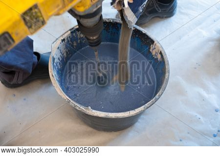 The Man Mixes The Mortar With A Perforator With A Special Nozzle. The Process Of Preparing Tile Adhe