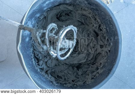 The Man Mixes The Mortar With A Perforator With A Special Nozzle. The Process Of Preparing Tile Adhe