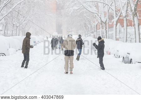The Picture Shows Some People Playing With Snow On The Street During A Copious Snowfall