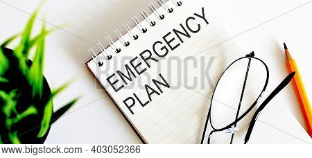 Mergency Plan - Business Concept Text On A White Notebook And Glasses, Pencil , Green Flowers