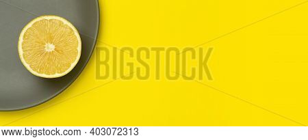Illuminating Yellow Lemon On A Ultimate Gray Plate On A Bright Yellow Background. Colors Of The Year