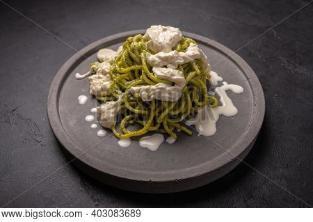 Close Up Pasta With Pesto, Stracciatella Cheese Served On Gray Ceramic Plate On Dark Grafit Backgrou