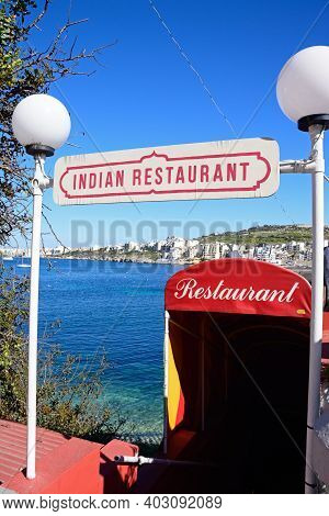 San Pawl, Malta - Apirl 2, 2017 - Indian Restaurant On The Waterfront With Views Towards St Pauls Ba