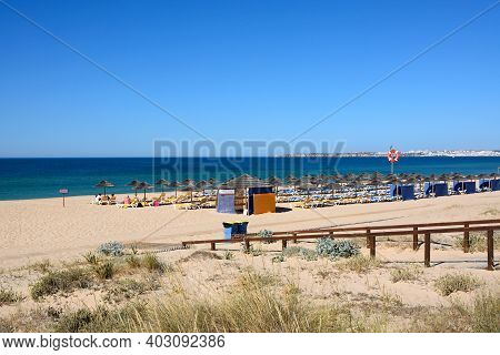 Alvor, Portugal - June 7, 2017 - Tourists Relaxing On The Sandy Beach With Views Towards The Atlanti
