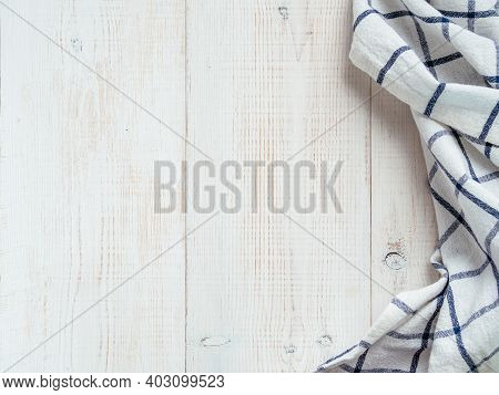 View From Above On White Wooden Table With Linen Kitchen Towel Or Textile Napkin. Blue Tablecloth On