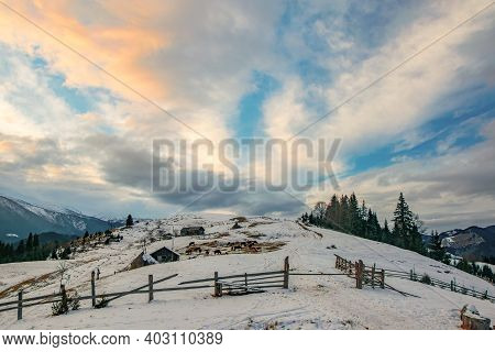 Farm On Mountain Range At Winter Evening. Picturesque Clouds Burning By Sunset. Dzembronya, Ukrainia