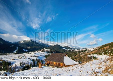 Early Spring Morning In Mountain Village. Wooden Houses On Foreground. Picturesque Clouds. Dzembrony