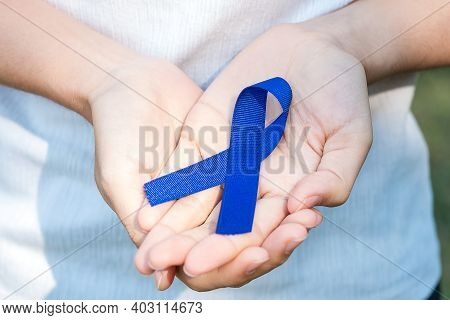 March Colorectal Cancer Awareness Month, Woman Holding Dark Blue Ribbon For Supporting People Living