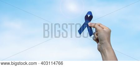 March Colorectal Cancer Awareness Month, Woman Holding Dark Blue Ribbon For Supporting People Living