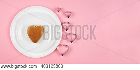 A Burger In The Shape Of A Heart Lies Beautifully On A White Plate.pink Background. Food For The Val