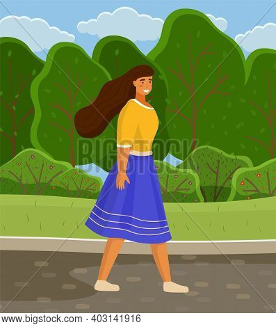 Young Girl In Blue Skirt And Yellow Blouse, With Long Hair Walks In City Park Or Forest. Green Trees