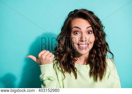 Photo Of Pretty Young Ecxited Girl Pointing Thumb Empty Space Wear Green Sweater Isolated Blue Color