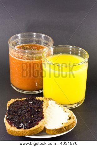 Orange Juice And Tomato Juice With Toasts With Raspberry Jam And Butter