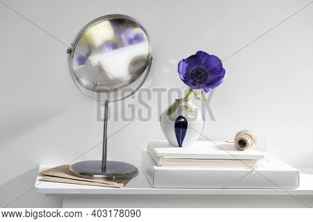 One Blue Anemone In A Multi-colored Vase In The Style Of The Seventies On The Table With Books As An