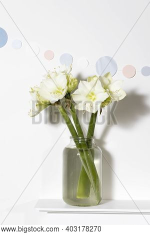 Bouquet Of White Lilies In A Tall Glass Vase On A Beige Table Against A Gray Wall. Copy Space. Fresh