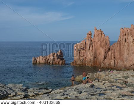 Arbatax, Sardinia, Italy, September 9, 2020: Two Young Men Jumping From Red Rocks, Rocce Rosse At Me