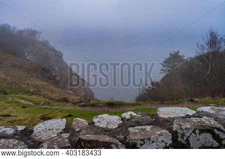 A View Over The Ocean From A Steep Hill A Misty Day. Picture From Kullen Nature Reserve, Scania Coun