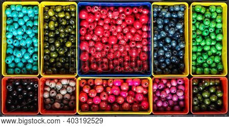 Colourfull Wooden Beads Sorted In Compartments By Colour In Plastic Box Organiser