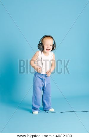 Joyful Boy Listening Music At Cord Headphones