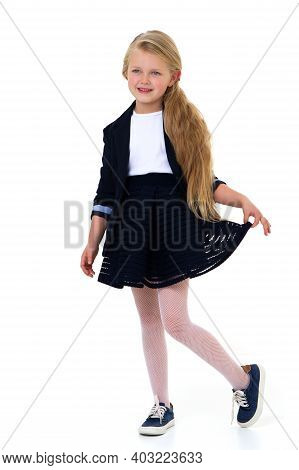 Cute Girl Elementary School Student. Cute Long Haired School Girl Wearing Blue Jacket And Skirt Posi