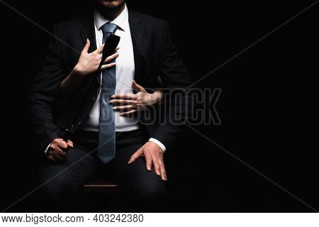 Female Arms Embrace A Male Dominant In A Suit With A Leather Whip Flogger. The Concept Of Bdsm Sex