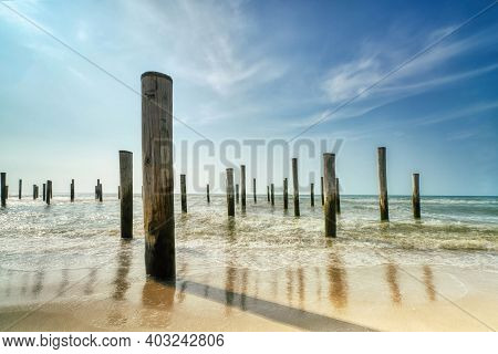 Long Exposure Seascape. Taken At The North Sea In Petten With The Pole Village In The Sea, Blue Sky,