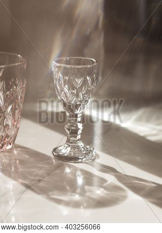 Soft Focus.variety Of Empty Glasses Diffrent Colors On Gray Stone Background With Hard Shadows And S