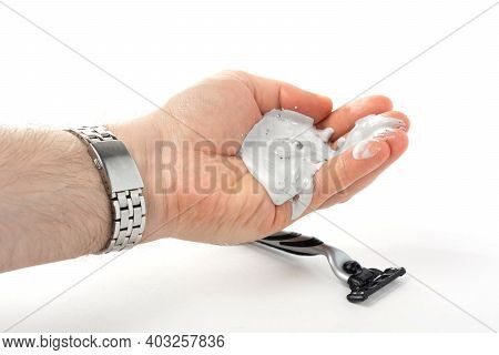 A Man's Hand With A Watch Bralet Holds A Shaving Cream In His Palm, A Shaving Machine Lies Below, A 
