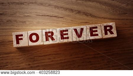 Forever Word On Wooden Cubes On Wooden Floor. Eternal Love Or Trustworthy Business Longterm Relation
