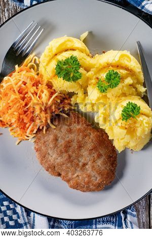 Homemade Minced Meat Cutlet Served With Mashed Potatoes And Carrot Salad.